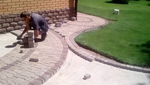 Укладка тротуарной плитки во дворе.