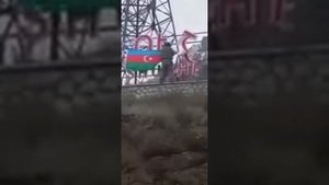 Азербайджанские солдаты водружают Азербайджанский флаг на надписи при въезде в город Шуша.