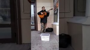 Слепой парень поёт песни о Боге на центральной площади города