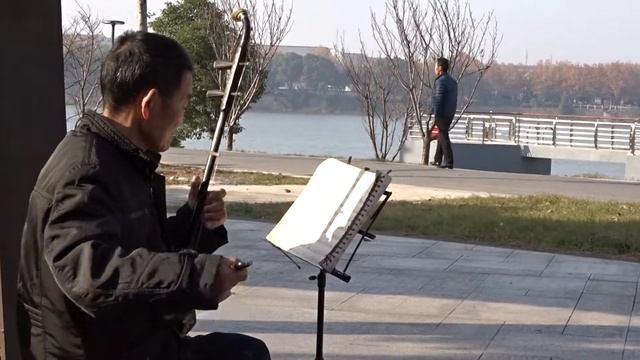 Playing a chinese ERHU spike fiddle on the YiWu River Promenade in Jinhua Zhejiang смотреть онлайн
