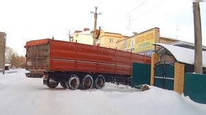 Водитель зерновоза не учёл габариты полуприцепа и зацепил заборчик.