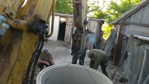 Установка колец ЖБИ экскаватором ЮМЗ. вес 1т.