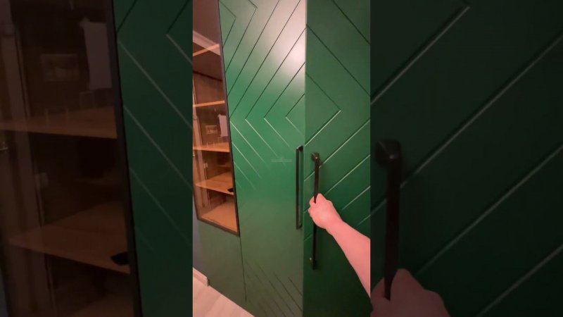 Шкаф в оригинальном зелёном цвете с геометрической фрезеровкой на фасадах, витриной и подсветкой.