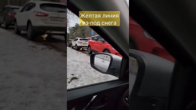 Желтая линия разметки из-под снега при парковке