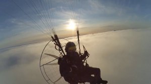 Параплан с мотором, полёт над облаками. Paraglider with a motor, flying over the clouds. Paramotor.