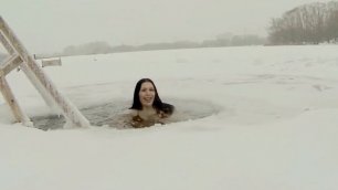 Молодая девушка купается в проруби