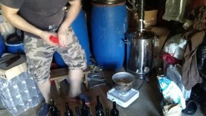 Укупорка винных бутылок корковой пробкой.