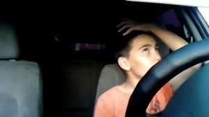 Мальчик сидит в машине и поёт песню