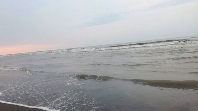 Вечернее Каспийское море и пляж с черным песком