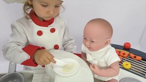 Милусик играет в повара и готовит кукле кашу