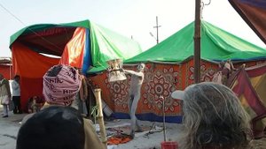 Кумбха Мела, молодой нага баба демонстрирует игру на дамару- барабане Шивы