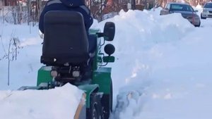 мини трактор переломка чистит снег.