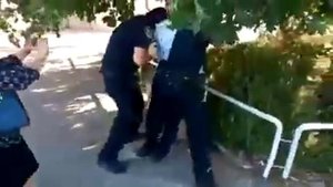 Полиция Израиля, пытается надеть наручники на человека, который нес маску на подбородке.