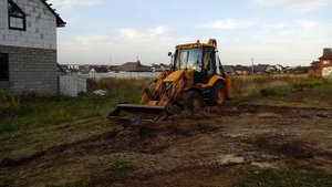 Экскаватор погрузчик делает планировку участка в Белгороде