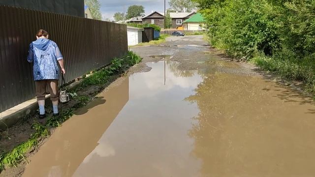 Женщина пытается обогнуть огромную лужу