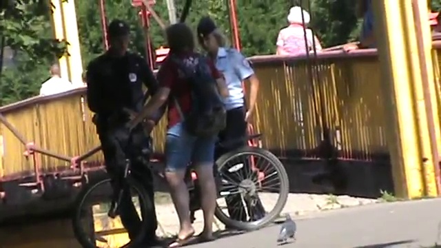 Полицейские сотрудники полиция разговаривают в парке с девушкой
