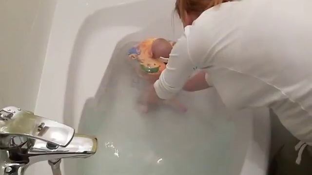 Плаванье младенцев в ванной с кругом.