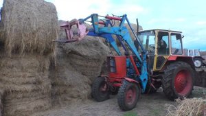 Чуть не придавило рулоном сена оператор на сеновале трактор