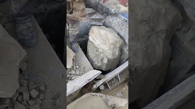 Workers and jaw crushers work together to crush large stones  limestone cobblestone basalt