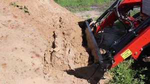 Погрузчик на Т-25 с челюстным ковшом в работе.