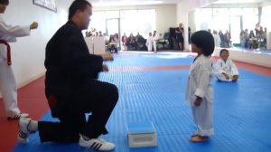 Малыш пытается разбить доску ударом ноги