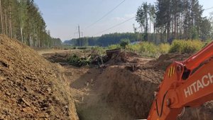 экскаватор делает подготовку грунта скального