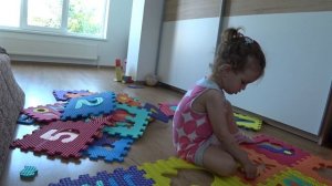Регина складывает пазл на полу с бабушкой - детские игры