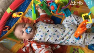 Как малыш лежит на коврике, выплевывает соску и радостно общается.