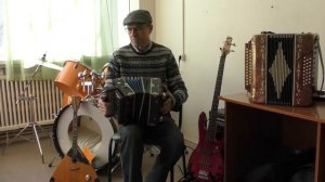 Гармонист Сергей Шалимов играет на старинной гармошке.