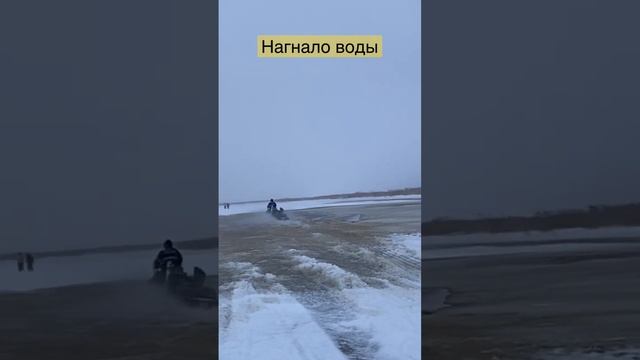 ?В плену у непогоды.Нагнало воды по колено,снегоход справился