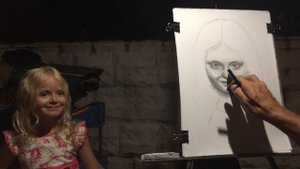 Художник портретист рисует портрет карандашом