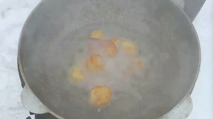 Картофель с мясом в казане на огне.