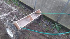 Сеялка-разбрасыватель для доломитовой муки, самодельная. A homemade seeder-spreader is in operation