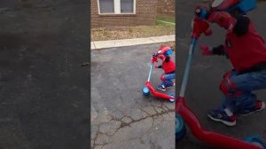 Riding his spiderman scooter