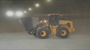 Сельскохозяйственный погрузчик JCB загружает зерно