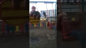 Как дети катаются на качелях