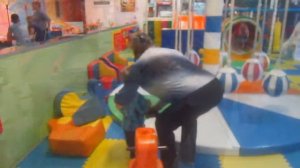 Дети играют в детской комнате и катаются на аттракционах. Детский развлекательный центр.