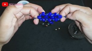 Браслет из ниток с кристаллами в центре.