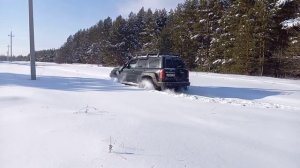 Ниссан Патрол 61 на 42 тракторах едет по снегу в небольшой подъем.21.02.21