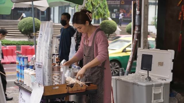 Красивая уличная бариста варит кофе в дождливый день в Бангкоке