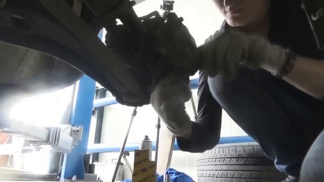 Девушка меняет тормозные колодки.