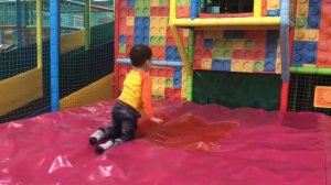 Давид весело играет на большой игровой площадке в разные игры