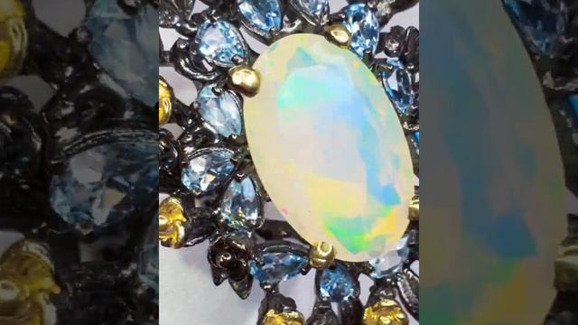 СЕРЕБРЯНОЕ ЧЕРНЕНОЕ И ПОЗОЛОЧЕННОЕ КОЛЬЦО с НАТУРАЛЬНЫМИ ОПАЛОМ (20Х13) И ГОЛУБЫМИ ТОПАЗАМИ смотреть онлайн