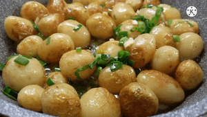 Молодой картофель жаренный на сковороде с зеленью и чесноком.