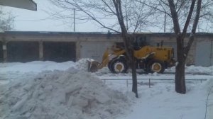 Фронтальный погрузчик  очищает от снега.