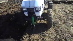 Самодельный трактор пашет землю.