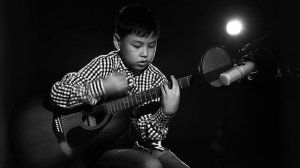 Казахский мальчик поет на гитаре