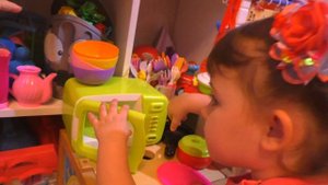 Дети играют игрушечной кухней. Лиза готовит обед для Артёма на кухне для детей