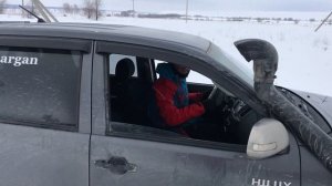 Тойота Hilux пробивает дорогу в глубоком снегу.