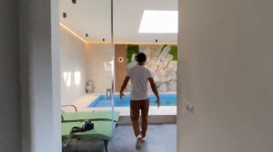 Акцентная стена из бетона в гостиной и скала с мхом в бассейне